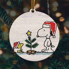 a christmas ornament with a cartoon character and a tree in the shape of a dog