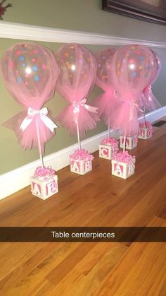 balloons and gift boxes are on the floor in front of a wall with pink bows