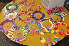 a table topped with lots of paper plates covered in different colored turkeys and faces