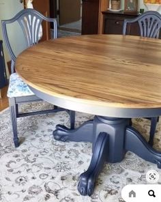 a dining room table with blue chairs and a rug on the floor in front of it