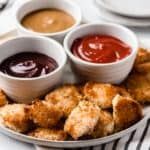 a plate full of food with sauces and dipping sauces on the plates next to it