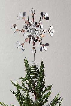 a christmas ornament hanging from a pine tree with snowflakes on it