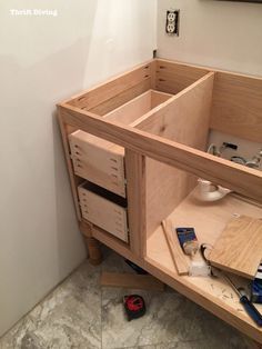 a wooden cabinet with tools in it sitting on the floor