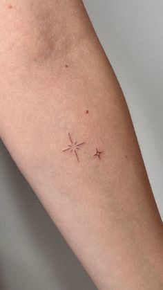 a woman's arm with two small stars on the left side of her arm