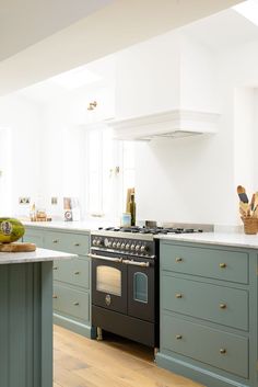 a kitchen with blue cabinets and an island in front of the stove, oven and dishwasher