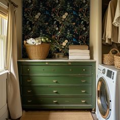 a washer and dryer are sitting in front of a wallpapered closet