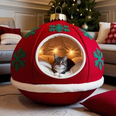 a cat sitting in a christmas ball shaped bed