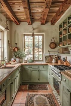 a kitchen with green cabinets and wooden beams in the ceiling, along with an area rug on the floor