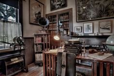 an old fashioned typewriter sitting on top of a wooden desk next to a window