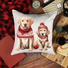 a pillow with two dogs wearing sweaters on it next to some bread and coffee