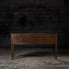 an old wooden table with two drawers on one side and a drawer on the other