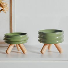 two green bowls sitting on top of a white counter