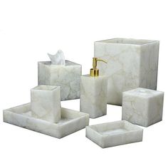 white marble bathroom accessories including soap dispenser, toothbrush holder and tissue dispenser