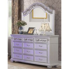 a white dresser with purple drawers and a mirror