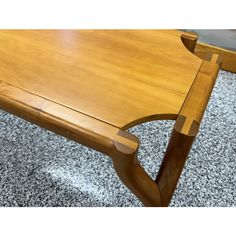 a wooden table sitting on top of a carpeted floor