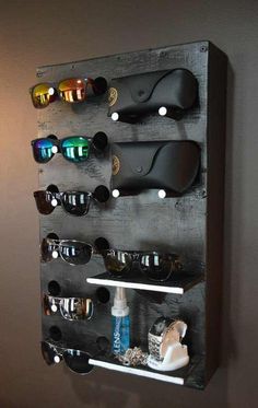 a wall mounted rack with sunglasses and other items on it in a bathroom area,