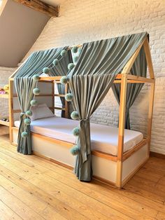 a bunk bed with curtains on the top and bottom is made from wood planks