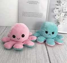 two stuffed animals sitting next to each other on a table