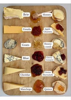 a wooden cutting board topped with lots of different types of cheeses and jams