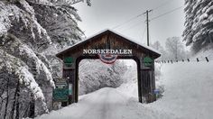 a wooden covered bridge over a snow covered road