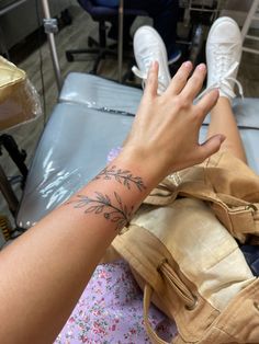 a person with a tattoo on their arm sitting in a hospital bed holding onto a bag