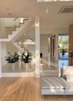 a living room filled with furniture and a staircase leading to the upper level bedroom area