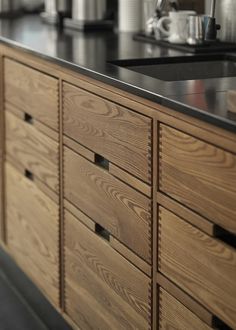 an image of a kitchen setting with black counter tops and wood cabinets in the background