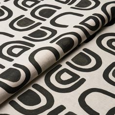 two black and white fabric designs on top of each other, one with an abstract design