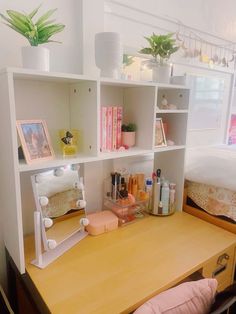 a desk with a mirror, shelf and other items on it next to a bed