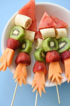 fruit skewers are arranged in the shape of birds