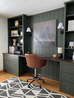 a home office with green painted walls and wooden flooring, along with an area rug