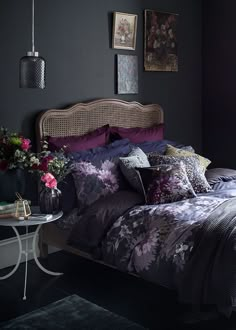 a bedroom with black walls and purple bedding