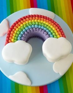 a rainbow cake with white frosting on a plate