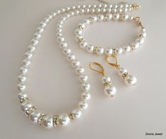 "This vintage inspired gold finish set comes with necklace, bracelet and earrings. Swarovski pearls in your color of preference. Makes a perfect gift for you, bridesmaids, maid of honor, mother of the bride or just for someone special! If you need a different color pearl contact me to check availability. Perfect for any classy bride! Necklace, This classic and elegant necklace has graduated Swarovski pearls. Pearls in the front of the necklace measure 10 mm and are separated with rhinestone roun Formal Gold Pearl Bridal Sets, Gold Pearl Drop Jewelry Sets For Anniversary, Anniversary Gold Jewelry Set With Pearl Drop, Classic Gold Jewelry Sets For Wedding, Classic Gold Bridal Necklace For Wedding, Gold Pearl Jewelry For Mother Of The Bride, Gold Elegant Jewelry Sets For Mother Of The Bride, Gold Pearl Bridal Sets As Gift, Gold Pearl Chain Jewelry Sets For Wedding