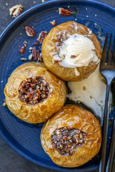 three pastries on a blue plate next to a fork and spoon with ice cream