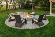 an outdoor fire pit with chairs around it