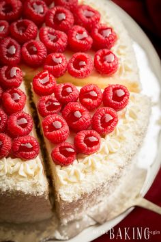 a white cake topped with raspberries on top of a plate