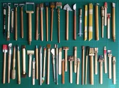 many different types of tools are laid out on a green board with blue grids