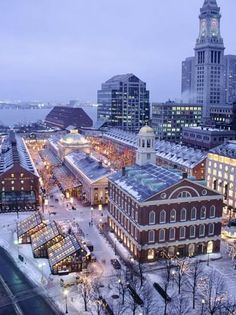 an aerial view of a city at night with snow on the ground and buildings in the background