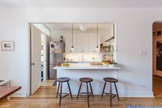 a kitchen with three stools in it