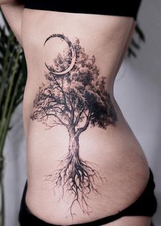 a woman with a tree and moon tattoo on her stomach