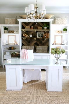 a white desk sitting in front of a bookshelf filled with lots of shelves