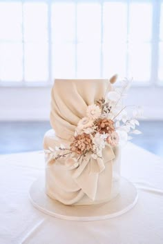 a white wedding cake with flowers on top