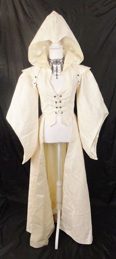 One of a kind - This is the only one available in this material! This is an extraordinarily beautiful jacket that is made of high quality vintage antique white damask upholstery fabric and fully lined in ivory bridal satin, to compliment the overall appearance. Front corset lacing closure with a set of 4 black metal grommets and ivory ribbon. Jacket also allows for additional fitting by use of the rear corset lacing which consists of a set of 5 black metal grommets. Jacket has a floor length bottom and has bell sleeves for that regal appearance. Jacket also comes with a detachable matching hood (attached with the use of ivory ribbon ties through black metal grommets). The high collar gives the jacket its royal feel and appearance, whether you are a fairy queen, snow queen, royal bride, or Fantasy Clothing Coats & Jackets, Fully White Outfits, White Ren Faire Outfit, Gown Overcoat, Dabloons Cat, Medieval Jacket, Damask Upholstery Fabric, Goddess Gown, Angel Outfit