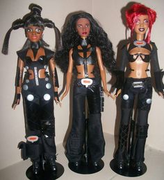 three dolls are standing next to each other in black outfits with red hair and piercings