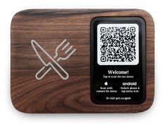 a wooden cutting board with a qr code on the front and a fork in the back