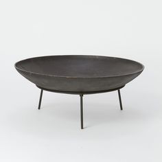 a black bowl sitting on top of a metal stand