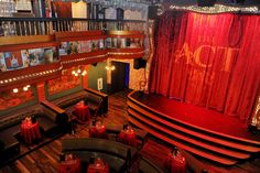 an empty theater with red curtains and lights on the stage, set for a show