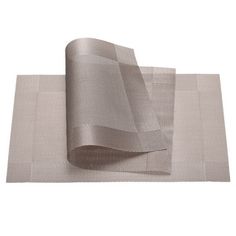 a roll of silver cloth on top of a white tablecloth next to a roll of gray fabric