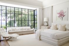 a bedroom with white furniture and large windows